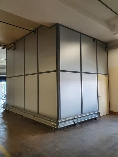Trennwandkonstruktion aus Stahlrahmen mit lichtdurchlässigen Füllungen in einer Halle
