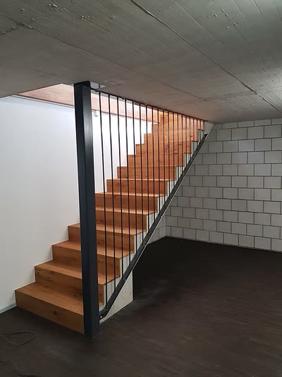 Kellertreppe mit anthrazitfarbener Stahlwange, Eichenstufen und Geländer mit senkrechten Stäben